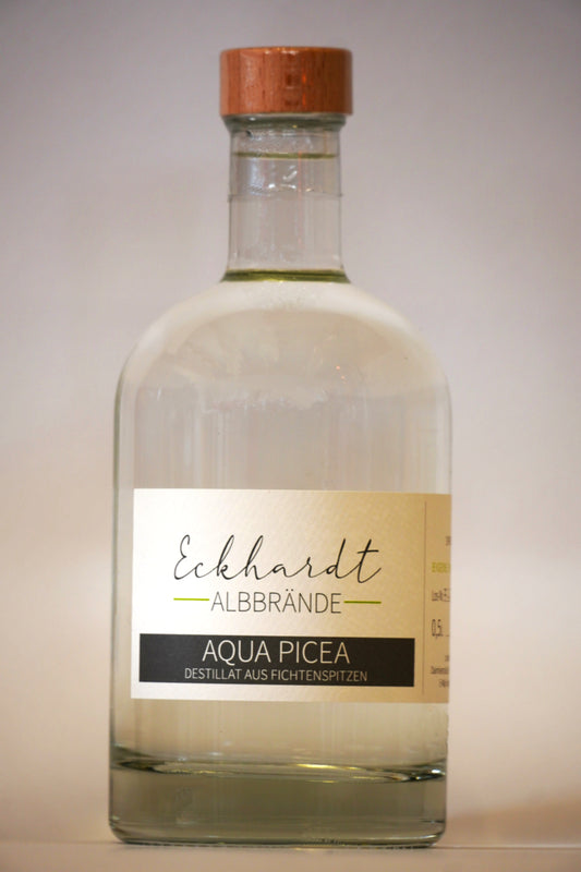 Glasflasche mit Holzdeckel vor einem weißen Hintergrund. Auf dem eleganten Etikett steht der Schriftzug "Eckhardt Albbrände" und die Bezeichnung "Aqua picea. Destillat aus Fichtenspitzen".